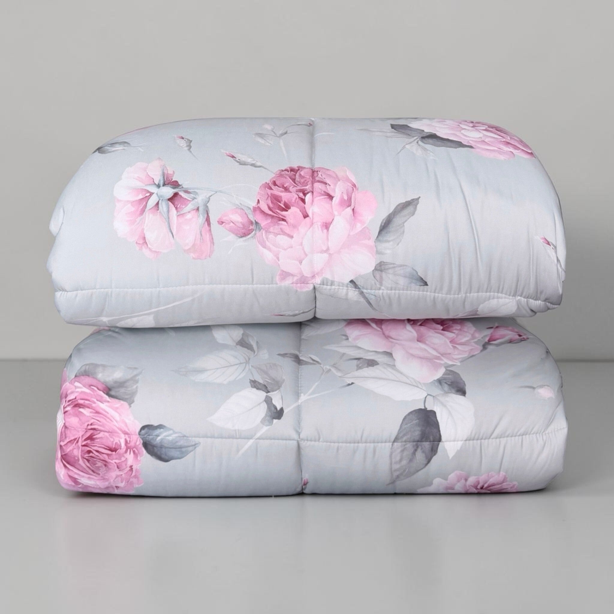 Trapunta Caleffi Bella Rosa piegata, con volume dell’imbottitura, trapuntatura a riquadri e fantasia floreale visibili