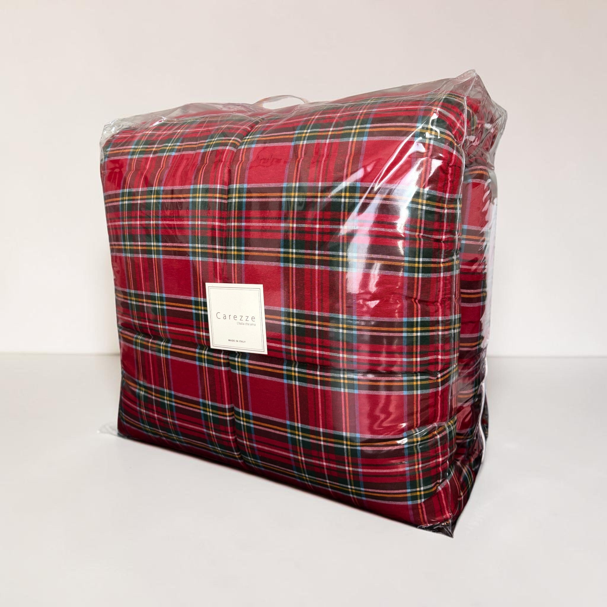 Trapunta Carezze Nataly tartan rosso confezionata nella borsa trasparente con manici ed etichetta del marchio.