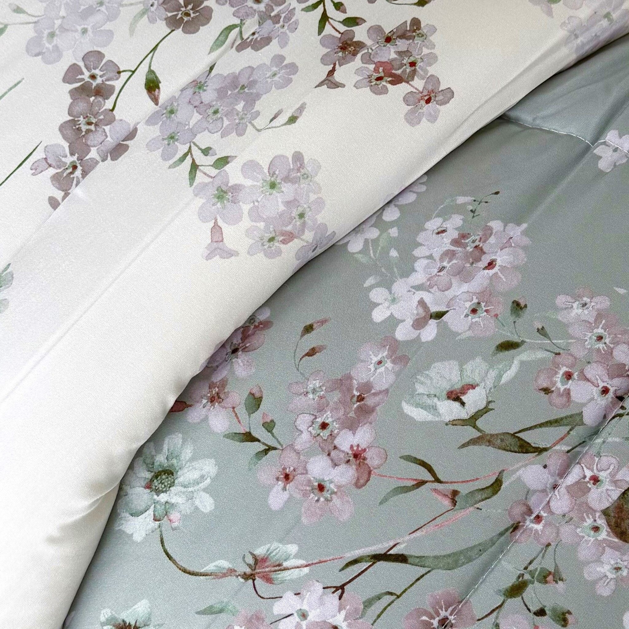 Primo piano dei due lati della trapunta Cogal 2620 Verde, con fiori rosa e lilla su fondi verde e avorio.