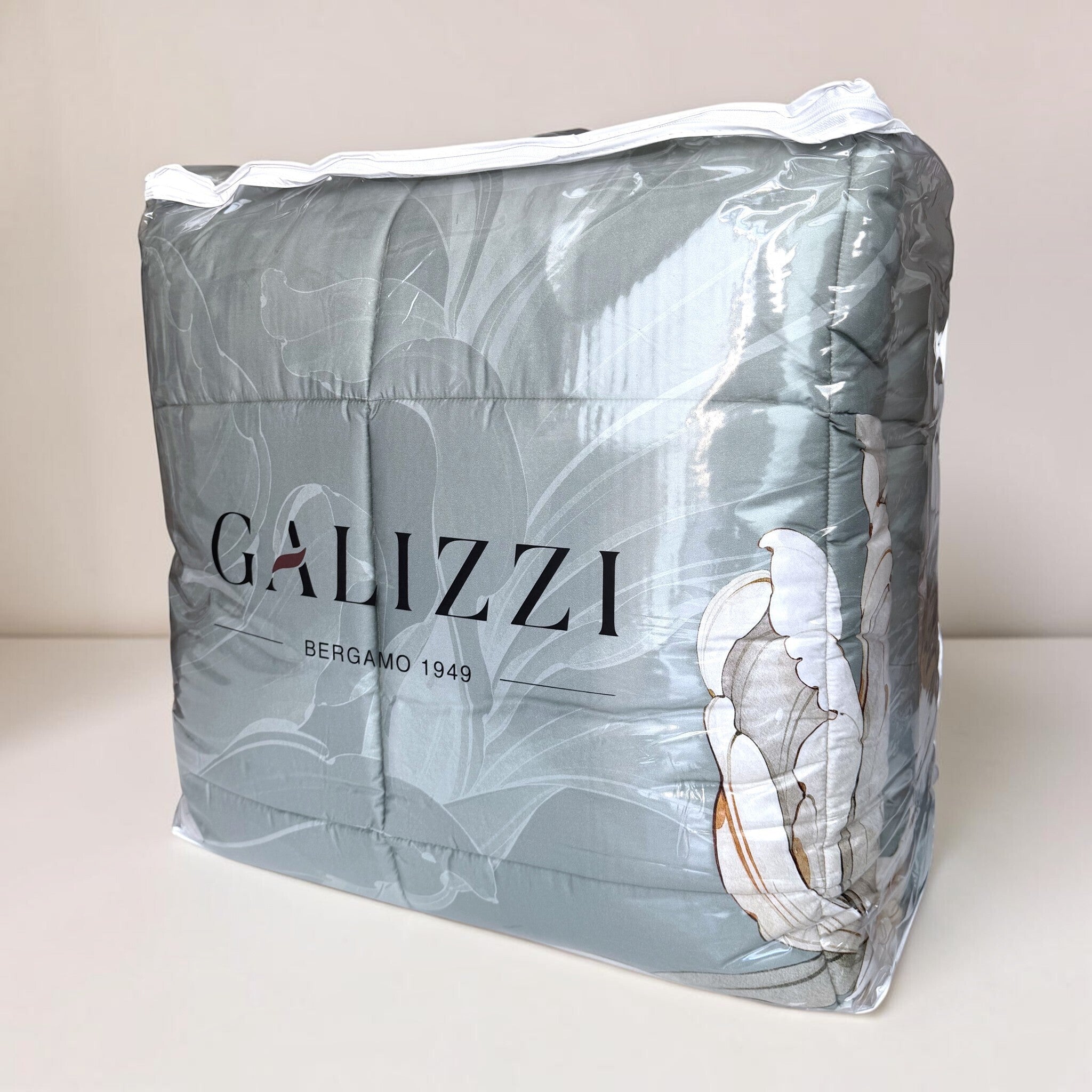 Trapunta Galizzi Lily Pietra nella borsa trasparente con cerniera e logo Galizzi, con stampa botanica visibile.