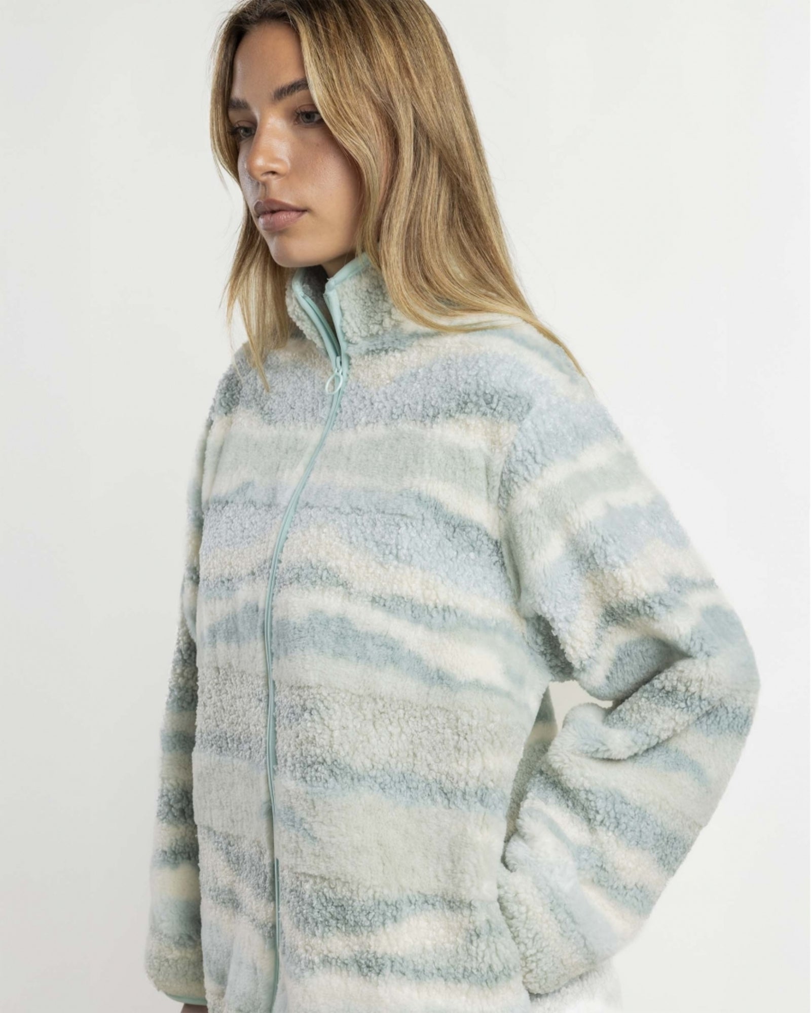 Dettaglio della vestaglia Admas 67414 in pile effetto sherpa, con collo alto, zip color acqua e mano nella tasca laterale