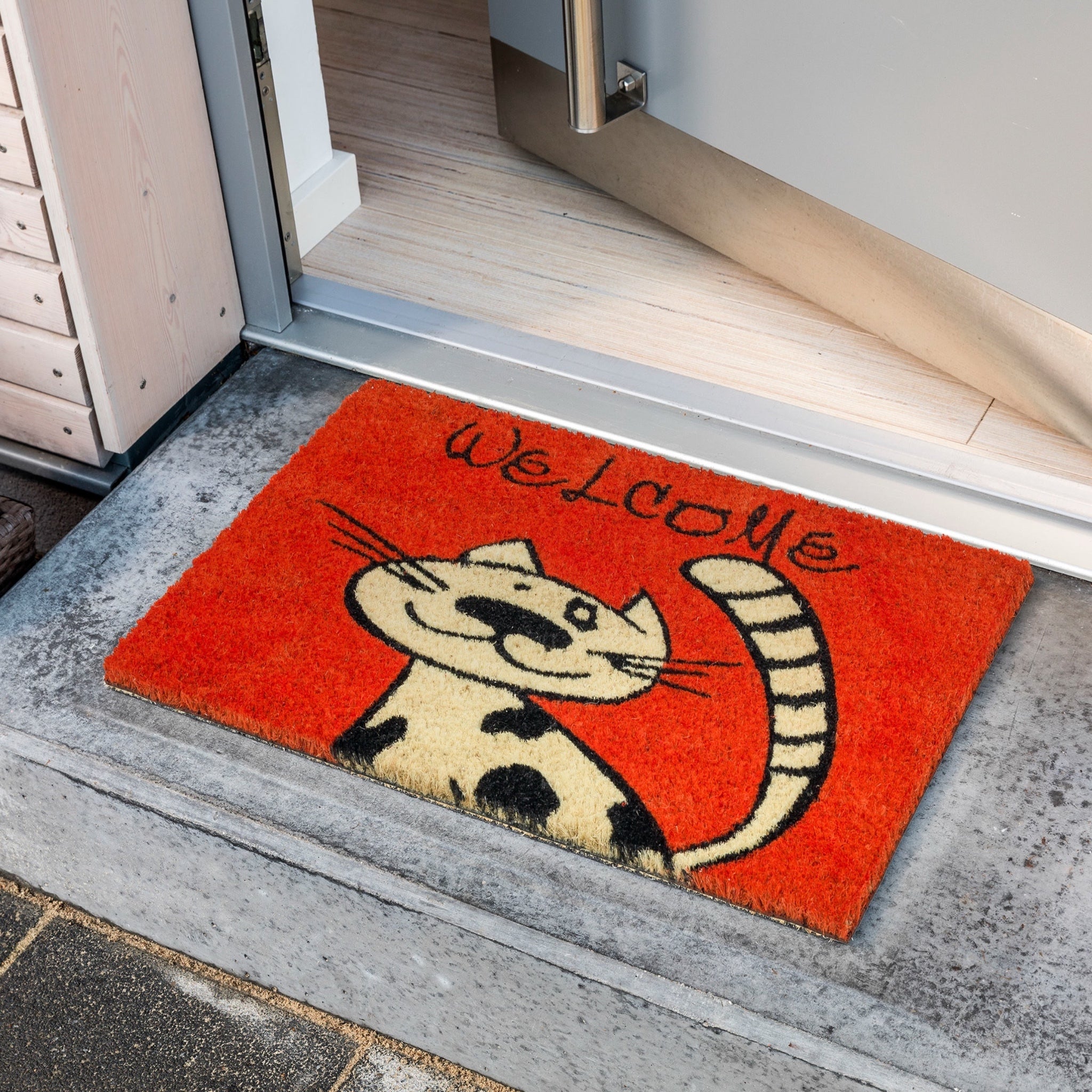 Zerbino rosso Coco Cat con gattino ambientato all’esterno davanti alla porta di casa