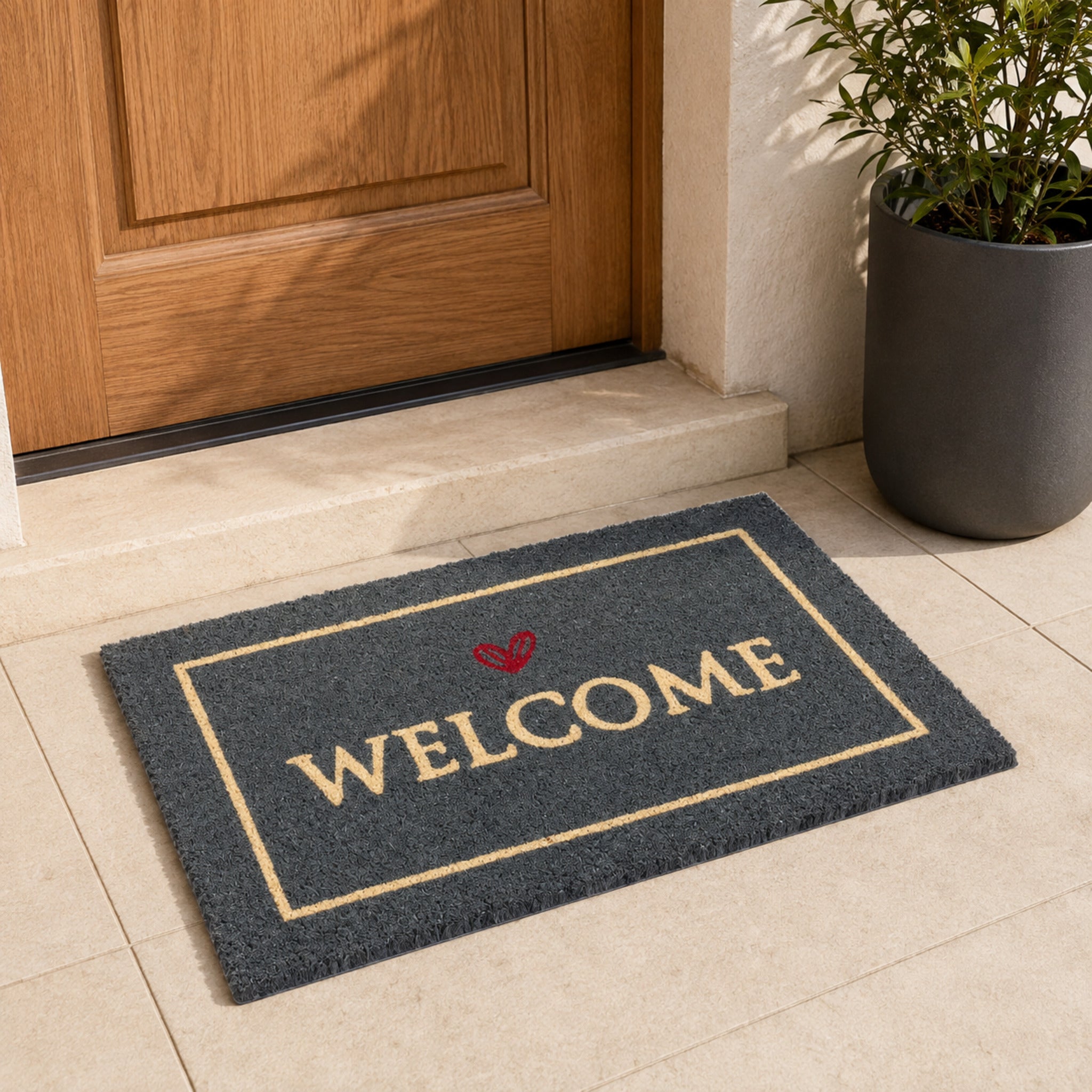 Zerbino Welcome 40 × 60 cm in cocco antracite con cuore rosso ambientato davanti alla porta di ingresso